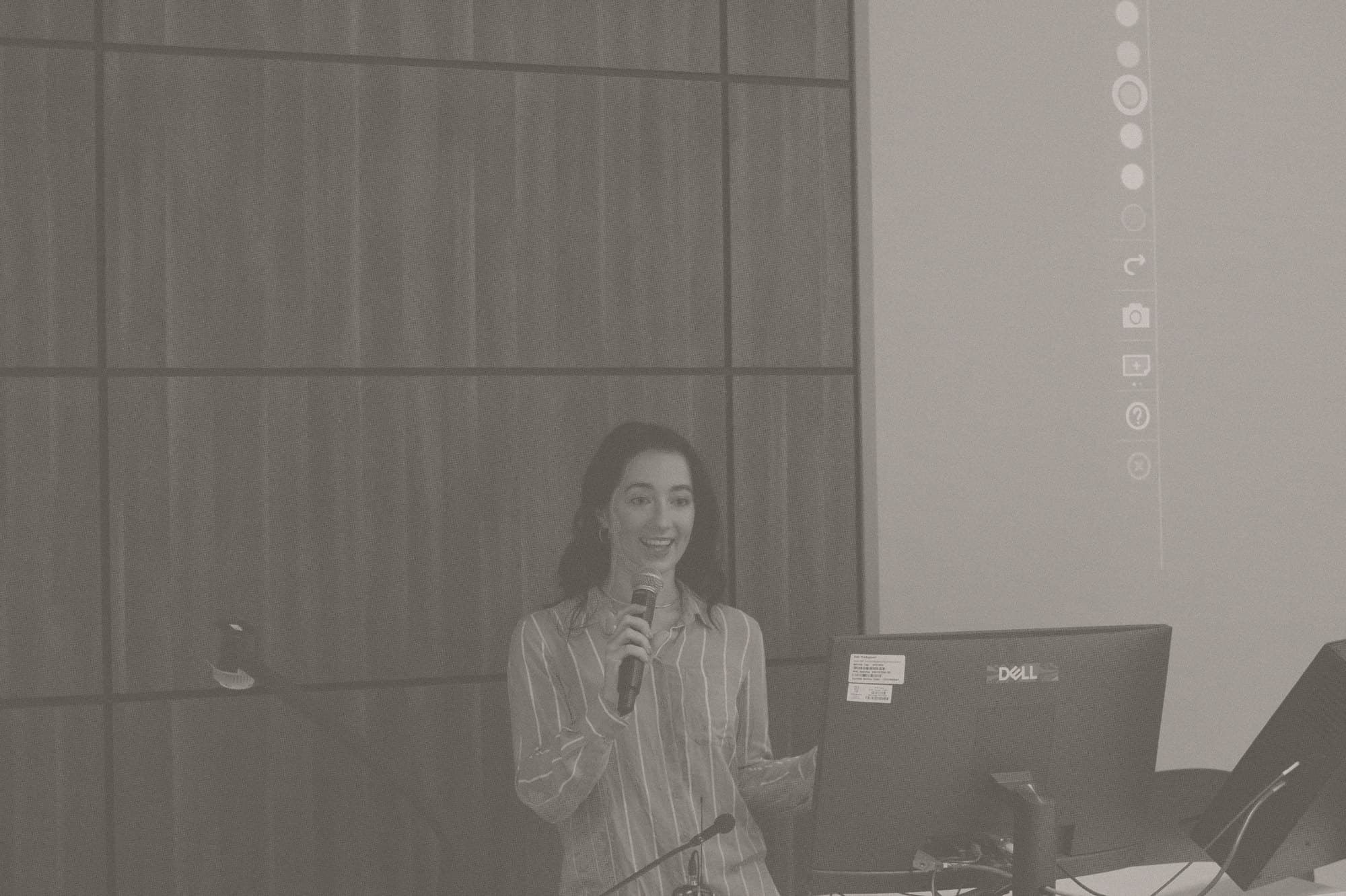 An Origami facilitator leading a hands-on AI workshop in front of a room, presenting from a laptop and screen